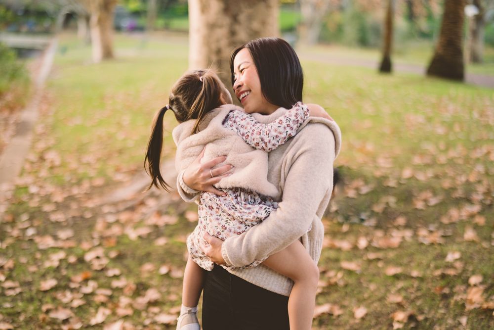 A mother lovingly holding and looking at her toddler during Autumn during an outdoor Perth family Photography session