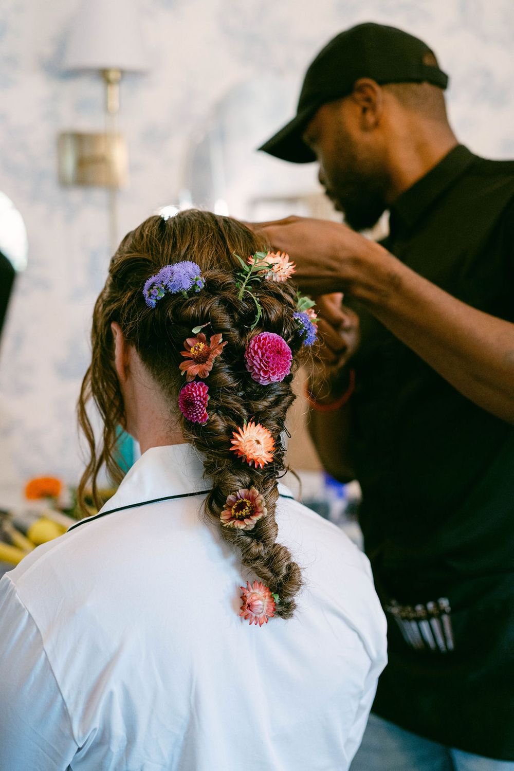 Behind the scenes preparation showing floral hair accessories being styled for a special event.