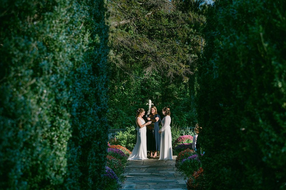 A couple celebrates their wedding day in a lush green forest setting with natural light filtering through trees.