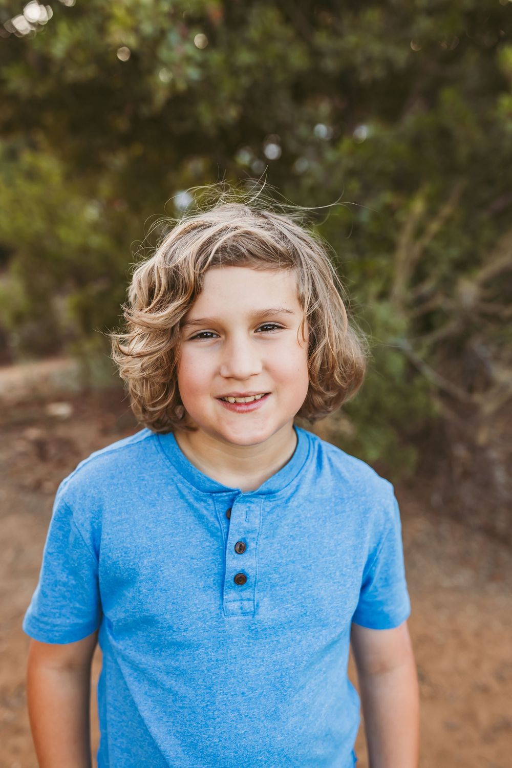 A series of four similar photos showing someone wearing a light blue henley t-shirt in an outdoor setting.
