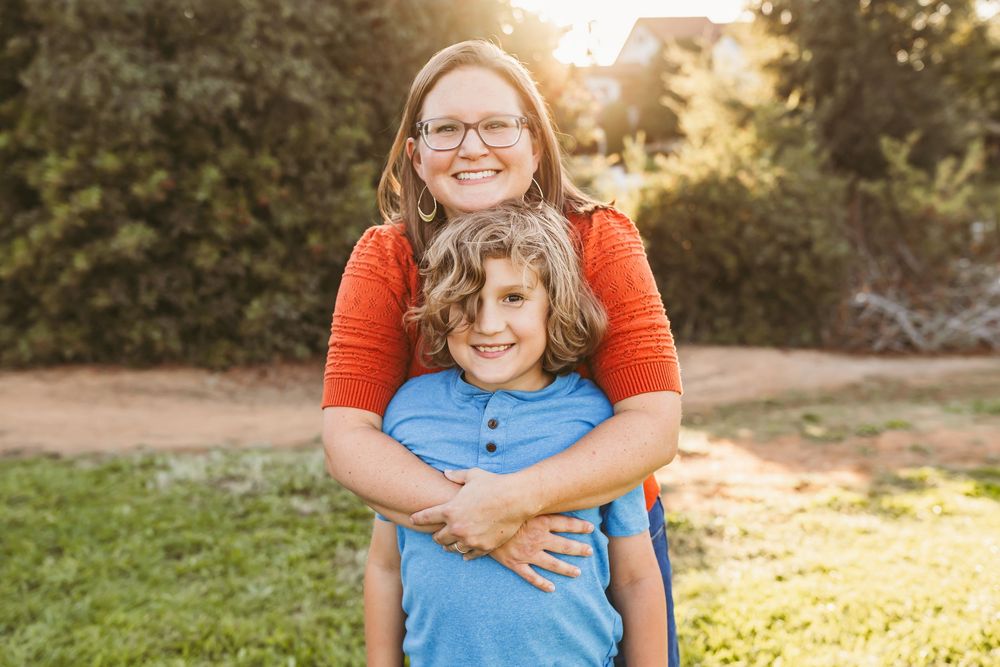 A series of outdoor family photos at sunset showing tender embraces between parent and child in casual blue and orange attire.
