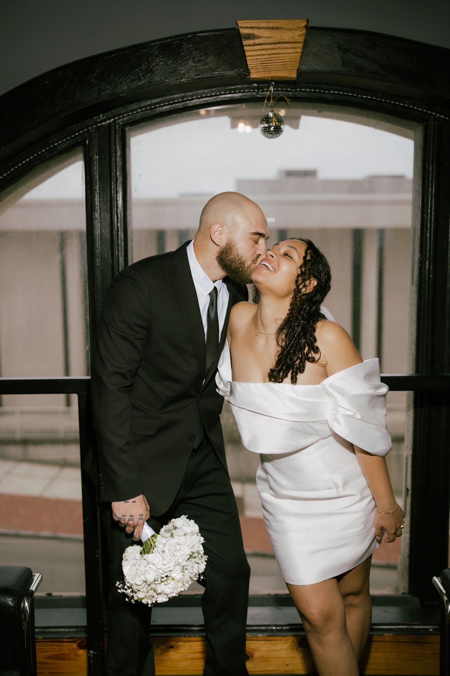 A romantic wedding couple shares intimate kisses under an arched doorway in a series of artistic black and white photos.