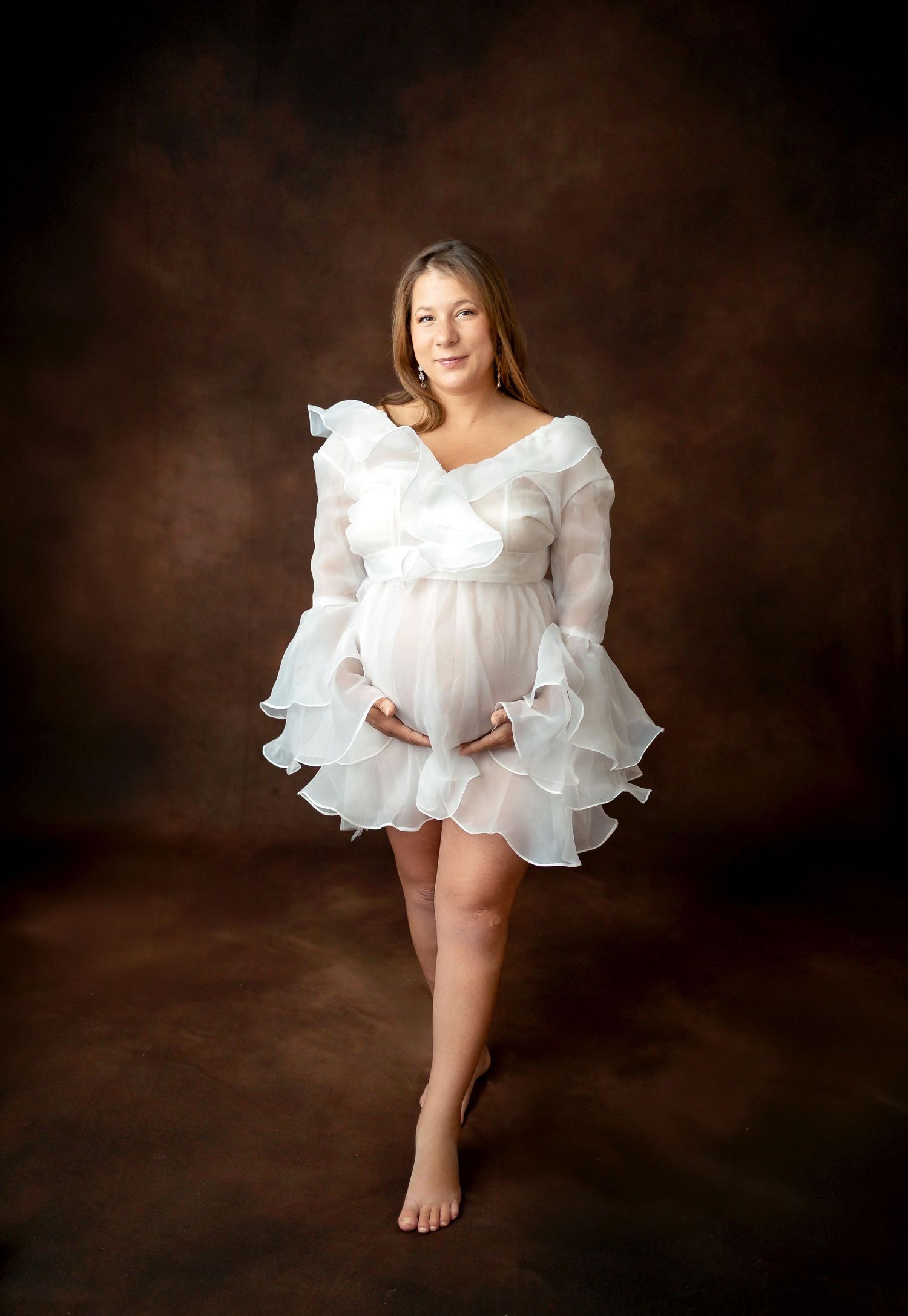 Vintage cream-colored nightgown with ruffled tiers and short flutter sleeves displayed on white hangers against a white wall.