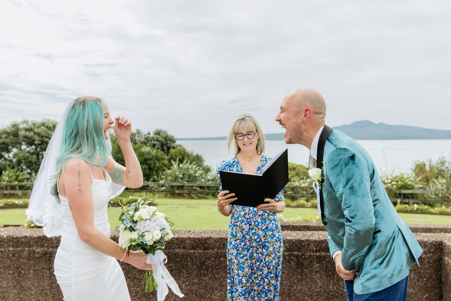 Auckland elopement photographer capturing a bride and groom laughing and looking at each other during their wedding ceremony at Bastion Pt