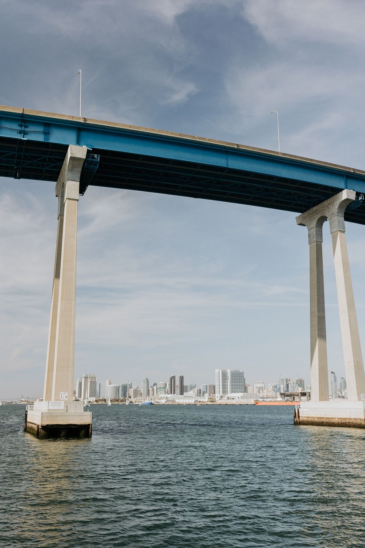 Panoramic view of the San Diego-Coronado Bridge spanning across the bay with downtown skyline visible in background.