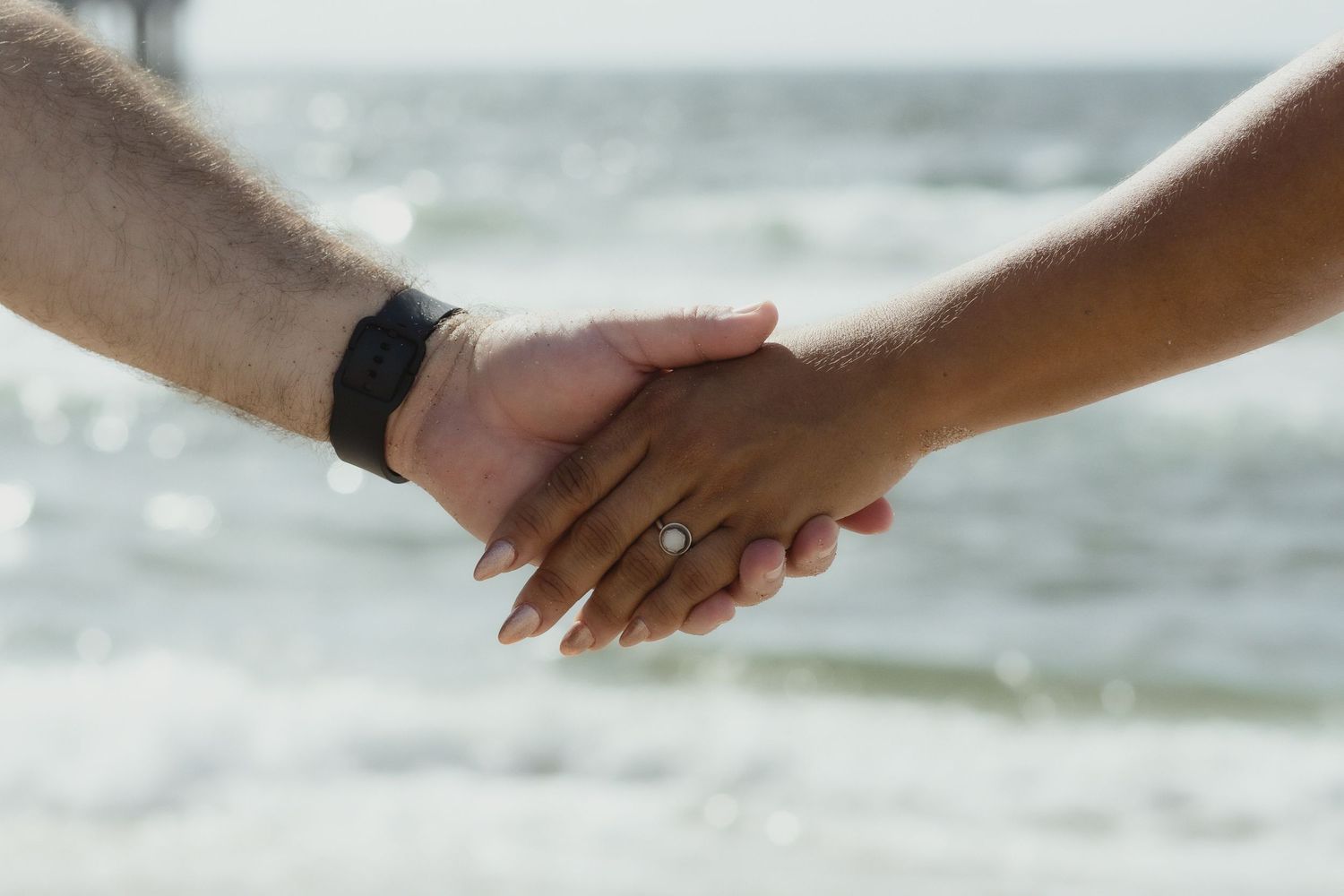 Couple holding hands in Pompano Beach Pier during engagement couples session.