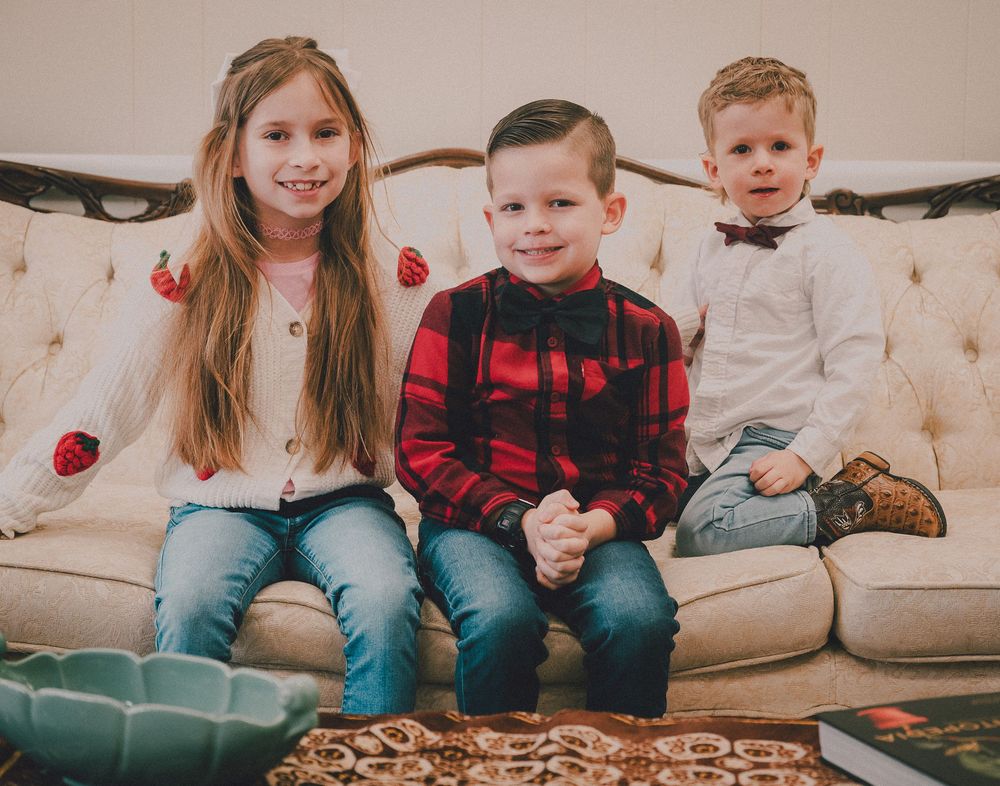 People sitting on a couch sharing pizza and enjoying a casual gathering together.