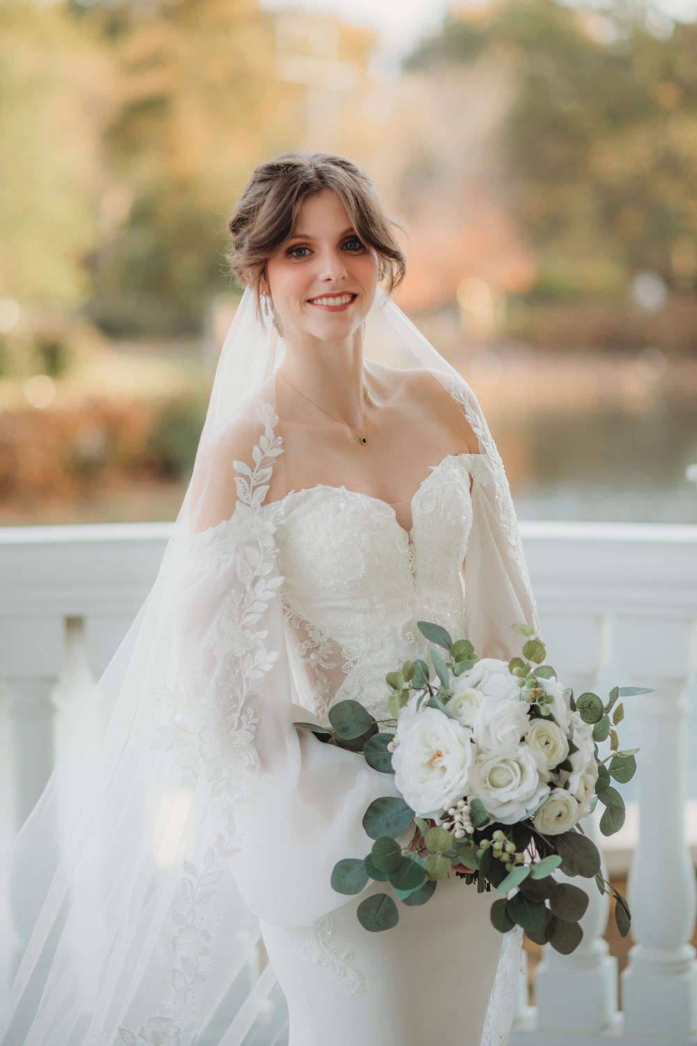 Beautiful bride in white fitted wedding gown with sweetheart neckline holds elegant bouquet of white roses and eucalyptus in Huntsville AL