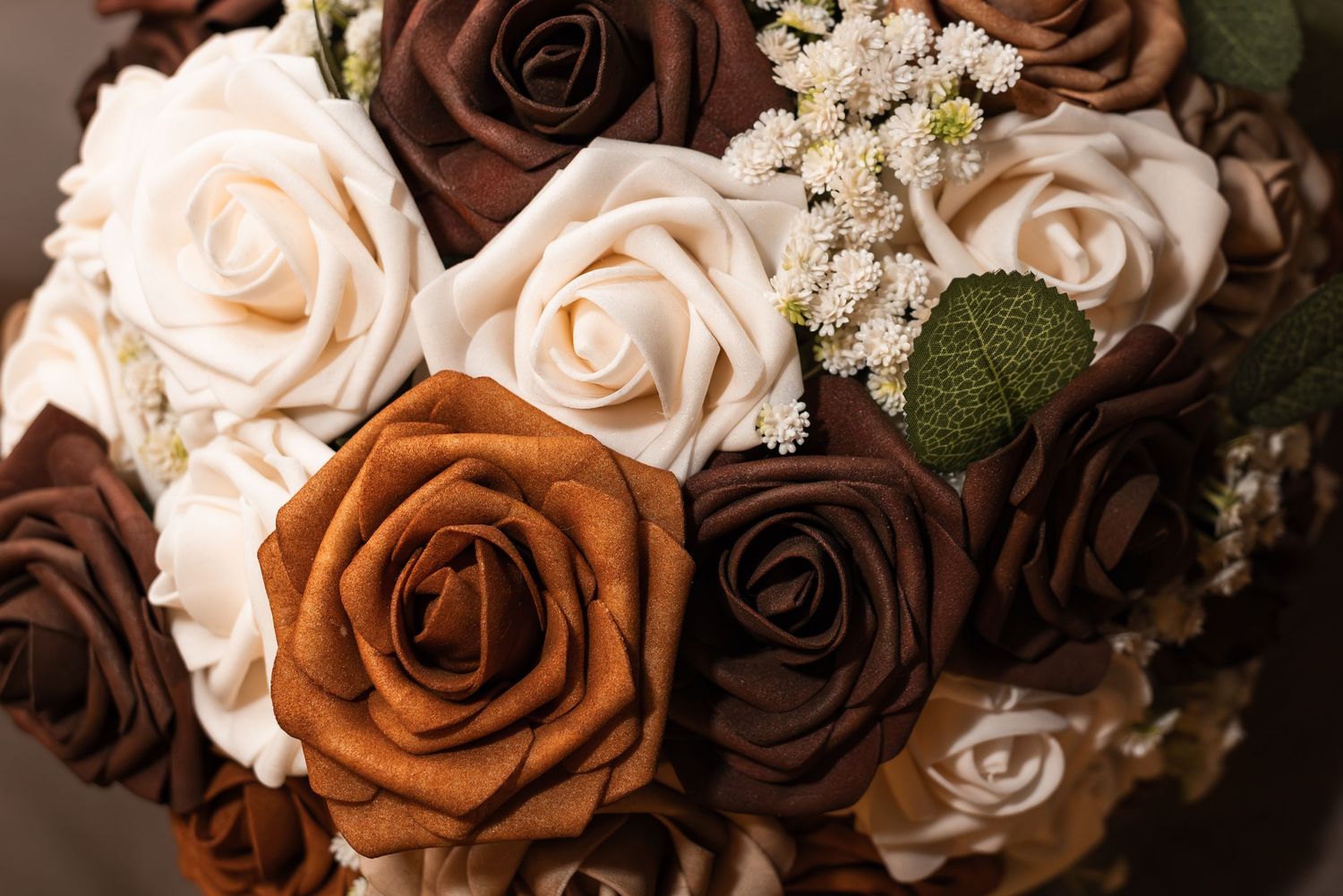 Close up view of brown and cream colored roses arranged in a romantic vintage style bouquet.