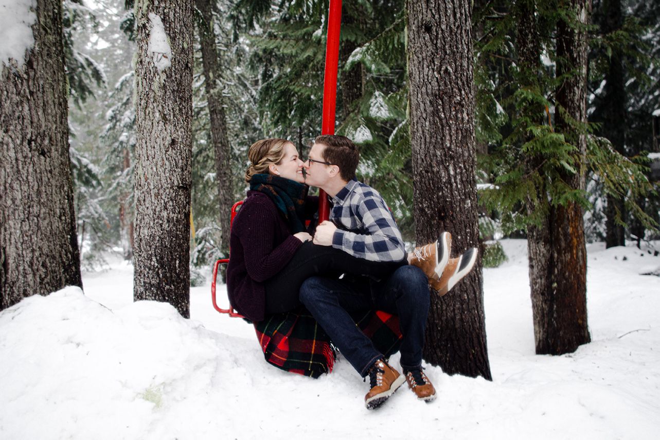 A romantic winter proposal sequence showing a couple in the snowy forest as they get engaged among tall evergreen trees.