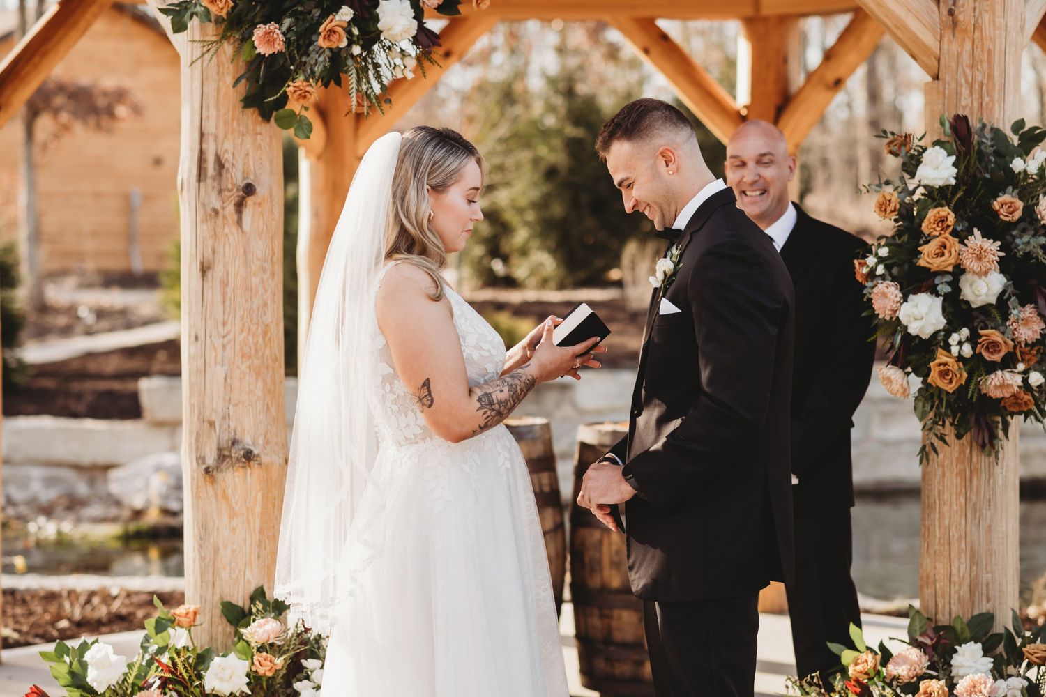 Bride is reciting her vows at the altar while the groom is smiling