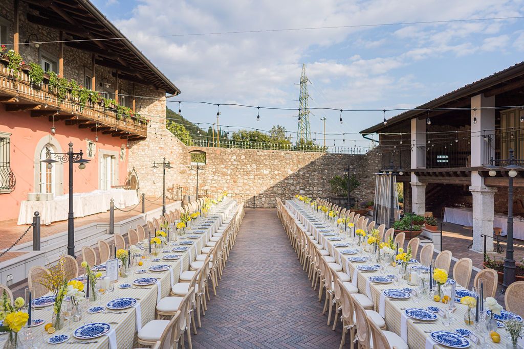 Colorful Indian textiles and bright linens decorating a rustic Italian wine resort garden.