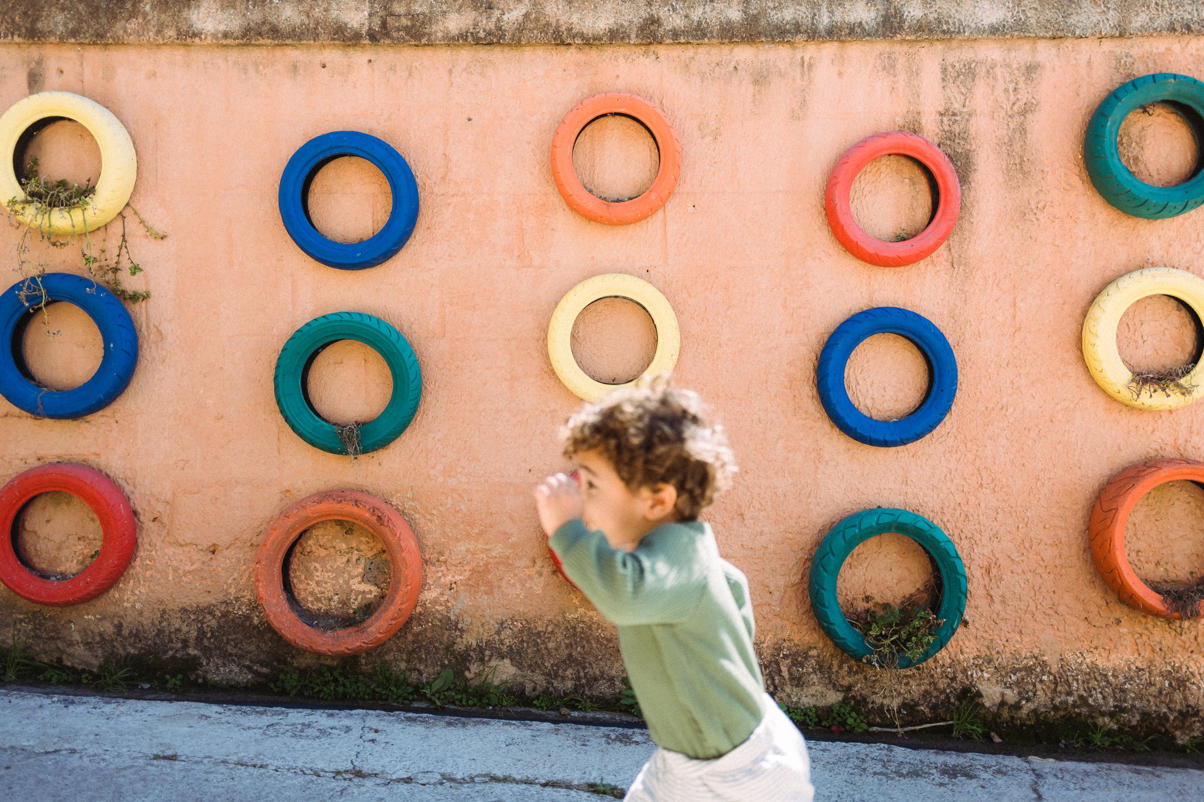A wall decorated with colorful circular rings in blue, red, and orange tones against a peachy background.