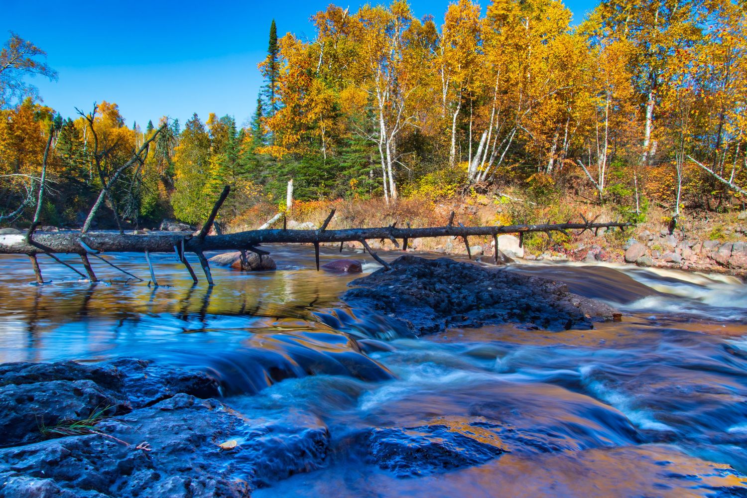 Long exposure fall waterfall landscape photography showing cascading water over mossy rocks on North Shore of MN , calming nature wall art.