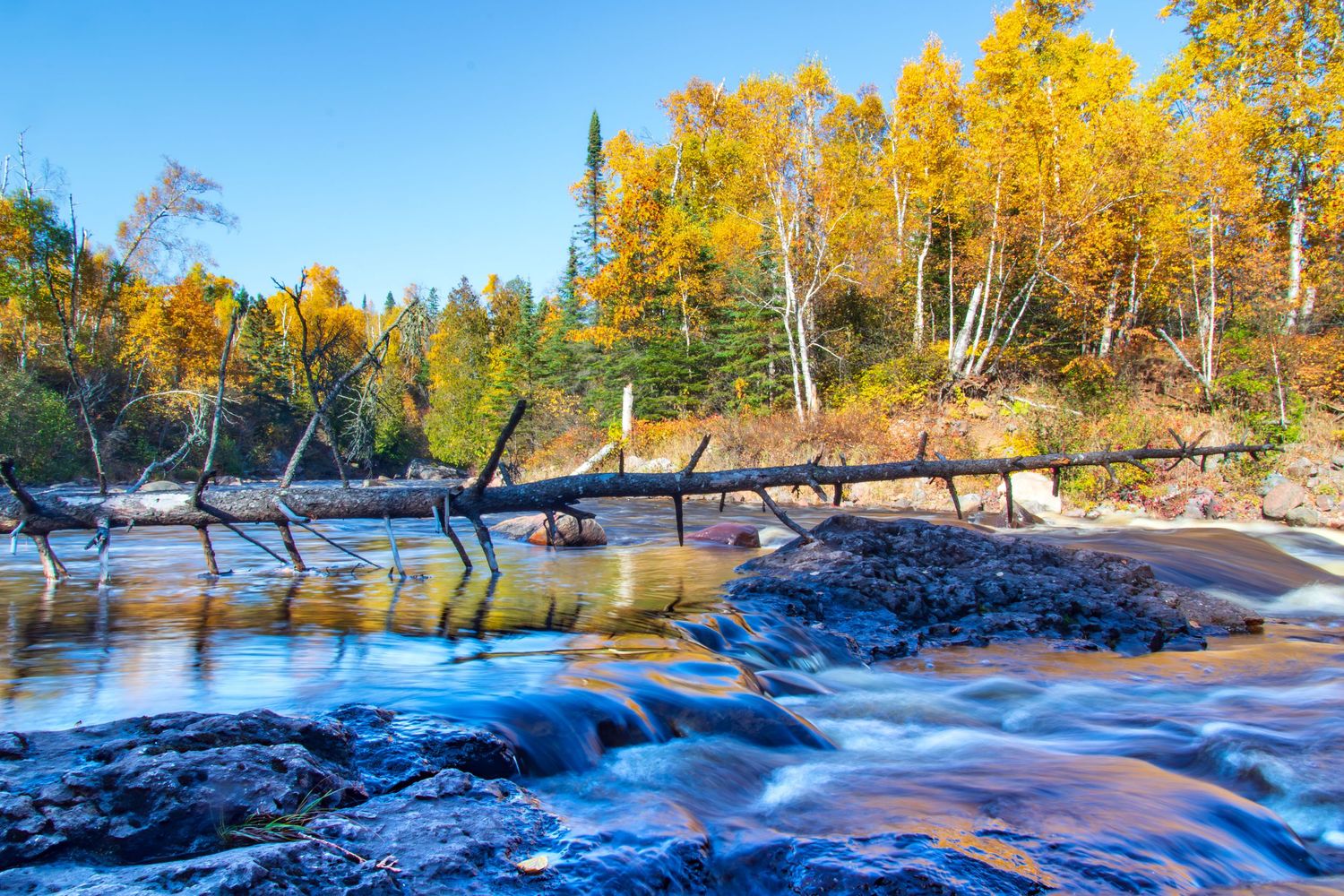 Long exposure fall waterfall landscape photography showing cascading water over mossy rocks on North Shore of MN , calming nature wall art.
