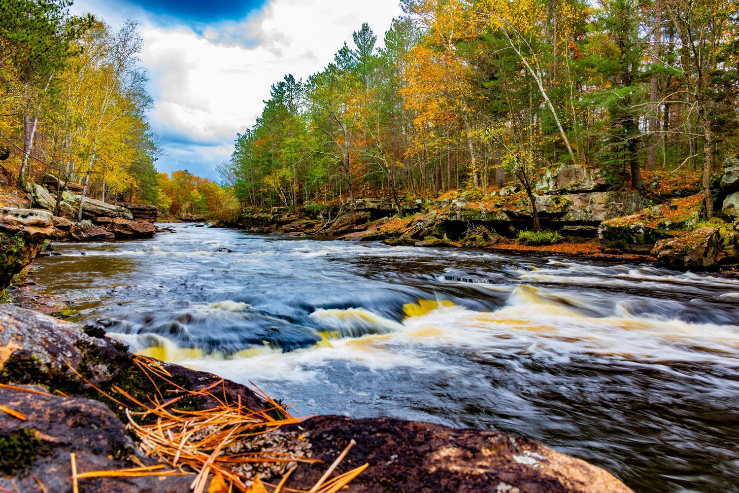 Long exposure fall waterfall landscape photography showing cascading water over mossy rocks in forest of Minnesota, calming nature wall art.