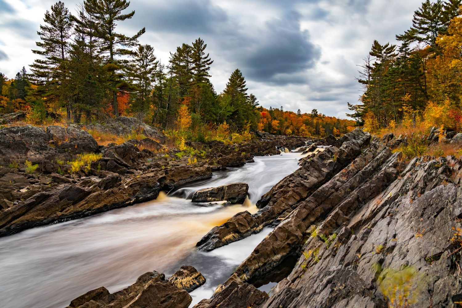 Long exposure fall waterfall landscape photography showing cascading water over mossy rocks in forests of Jay Cook, calming nature wall art.