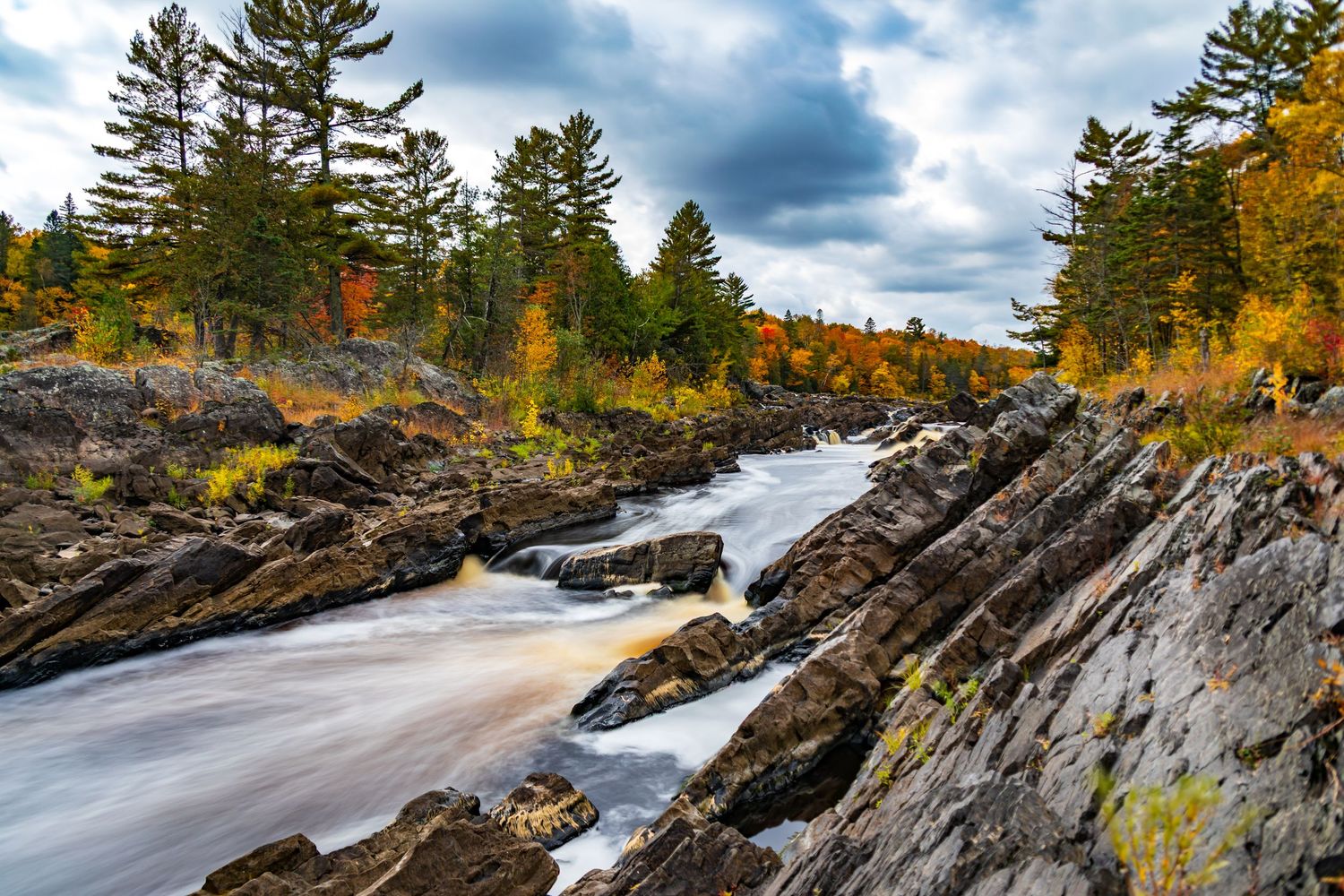 Long exposure fall waterfall landscape photography showing cascading water over mossy rocks in forests of Jay Cook, calming nature wall art.
