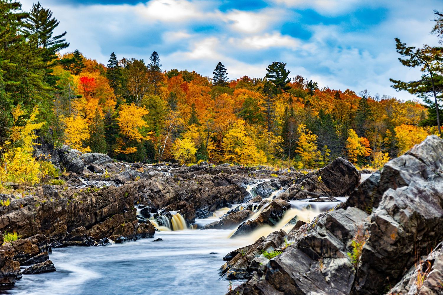 Long exposure fall waterfall landscape photography showing cascading water over mossy rocks in forests of Jay Cook, calming nature wall art.