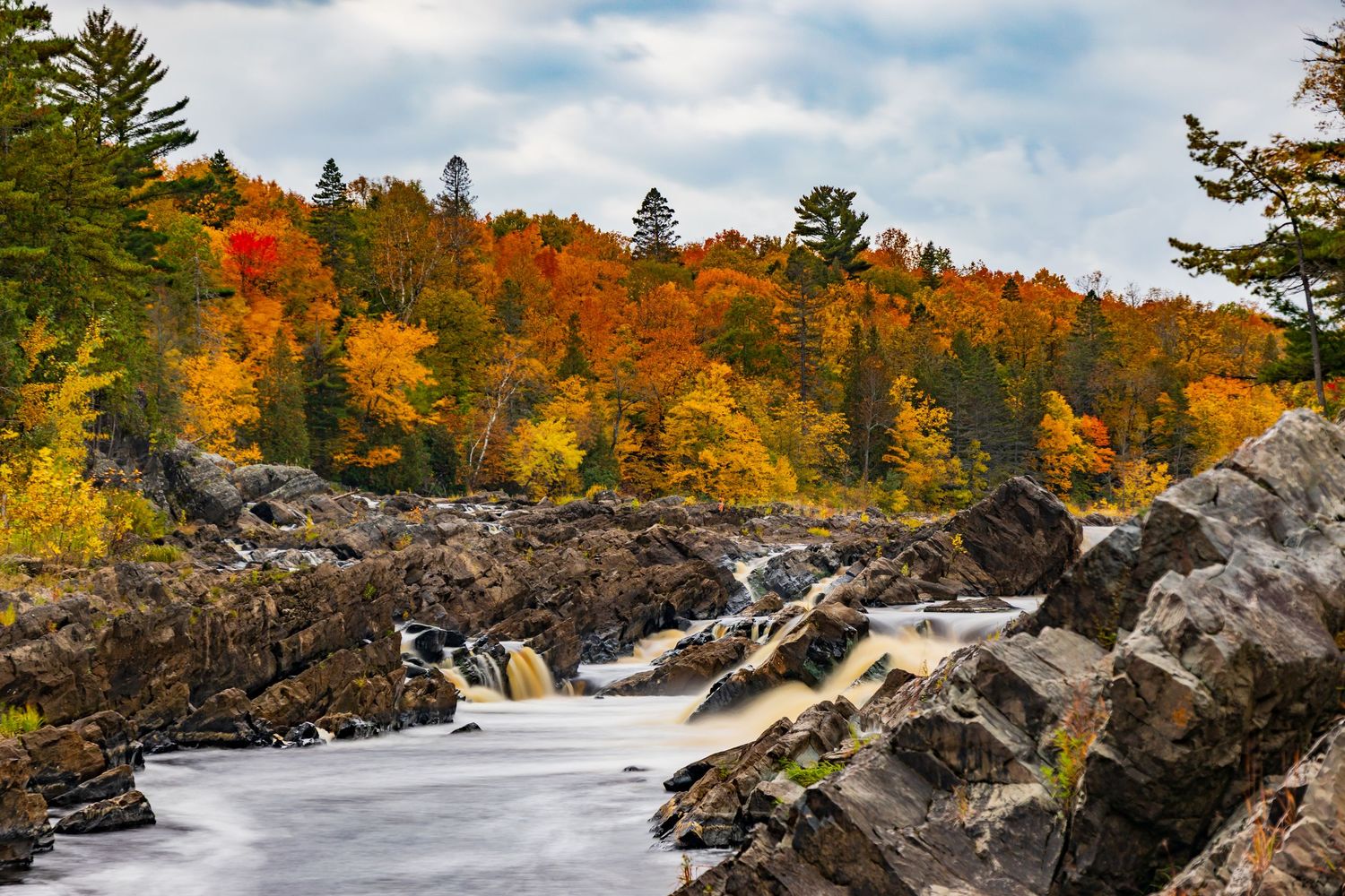 Long exposure fall waterfall landscape photography showing cascading water over mossy rocks in forests of Jay Cook, calming nature wall art.
