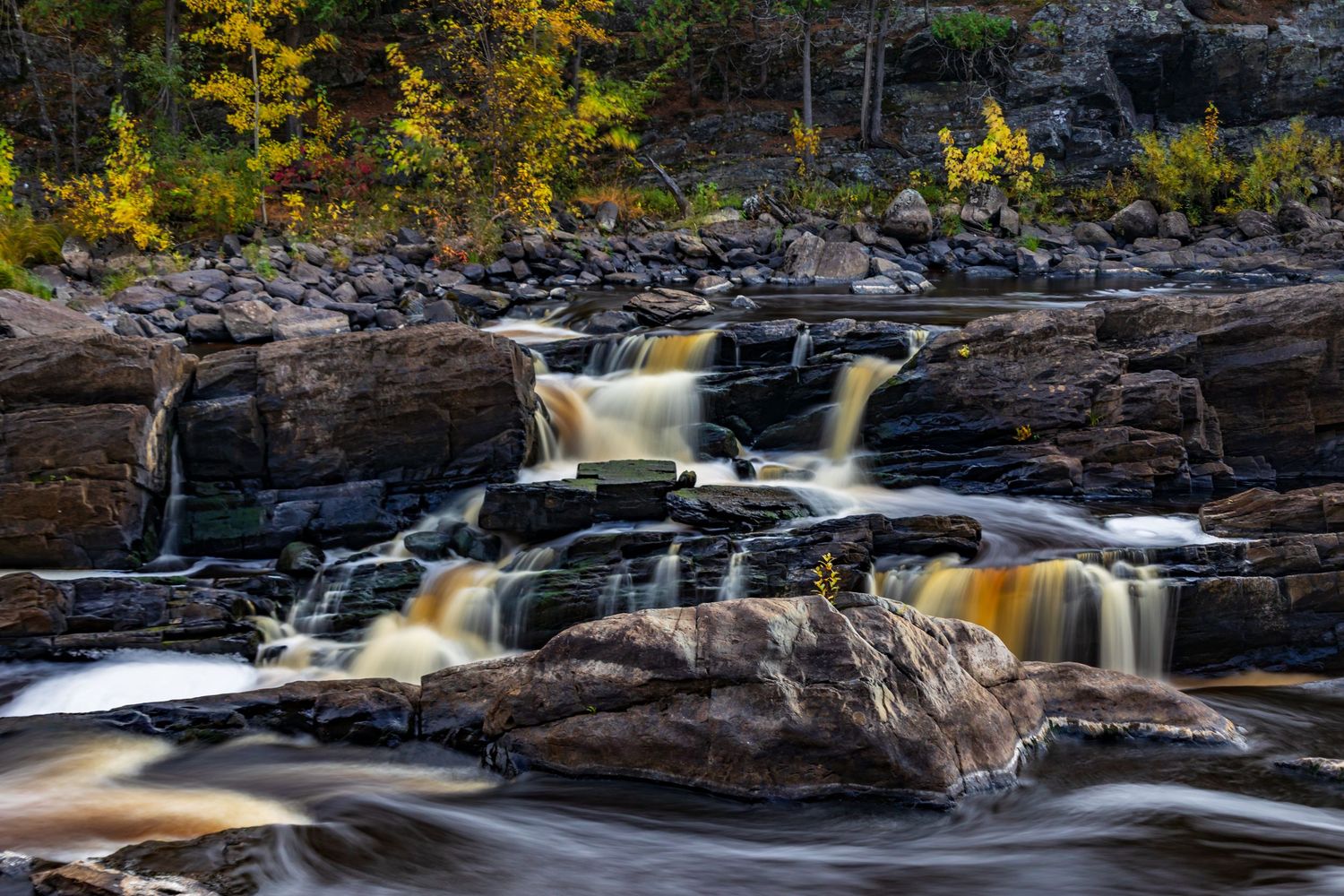 Long exposure fall waterfall landscape photography showing cascading water over mossy rocks in forests of Jay Cook, calming nature wall art.