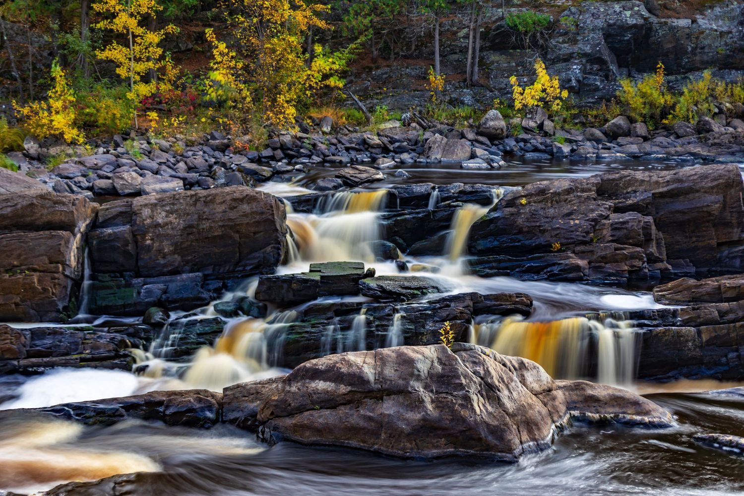 Long exposure fall waterfall landscape photography showing cascading water over mossy rocks in forests of Jay Cook, calming nature wall art.