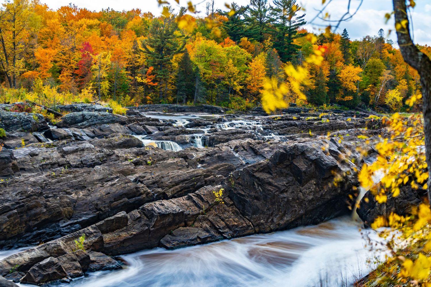 Long exposure fall waterfall landscape photography showing cascading water over mossy rocks in forests of Jay Cook, calming nature wall art.