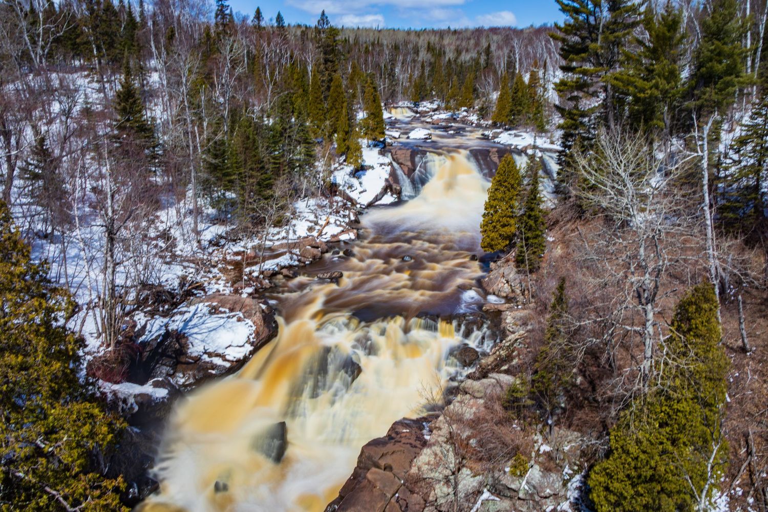 Long exposure waterfall landscape photography showing cascading water over mossy rocks in forests of Northern MN, calming nature wall art.