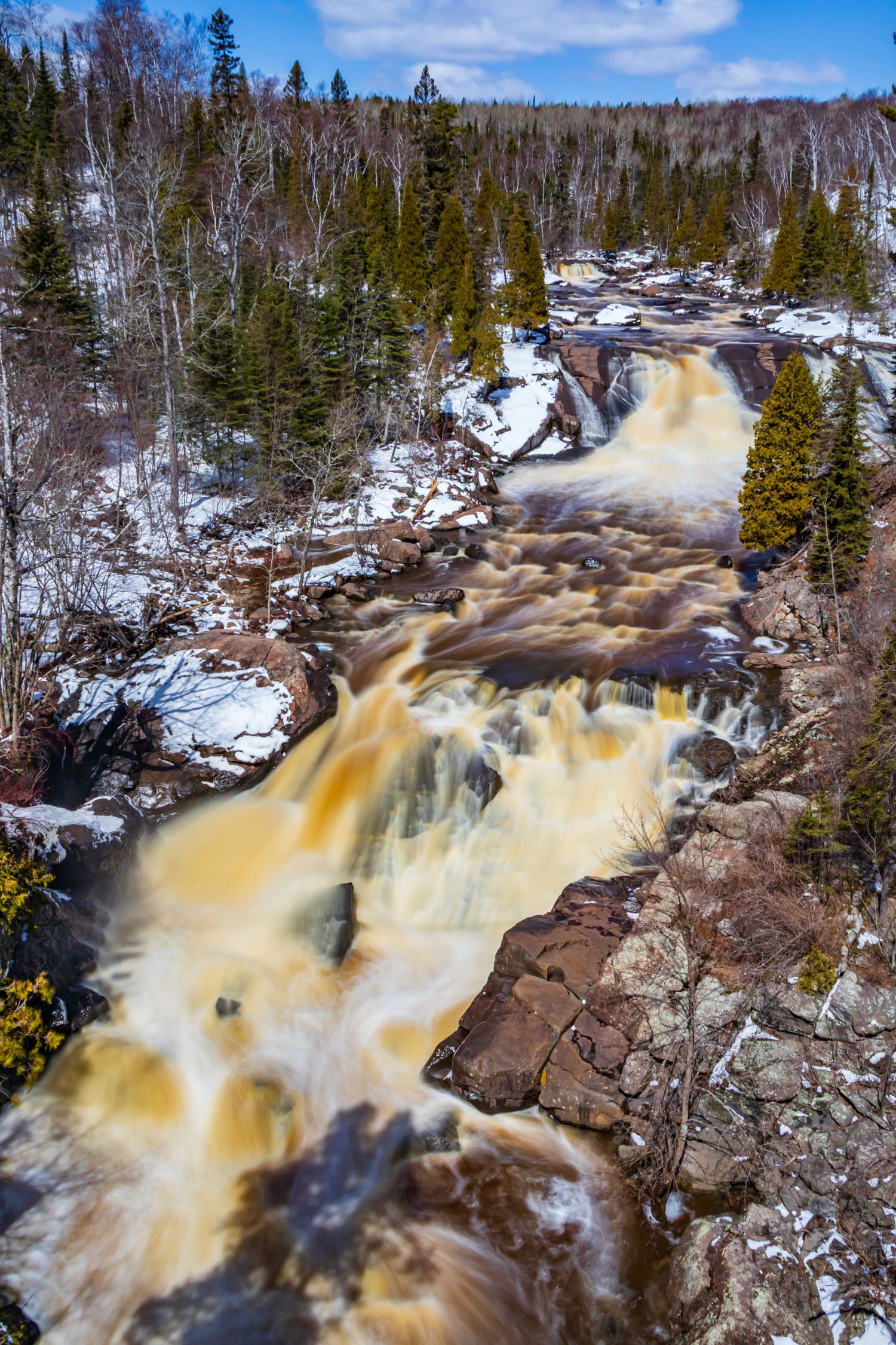 Long exposure waterfall landscape photography showing cascading water over mossy rocks in forests of Northern MN, calming nature wall art.