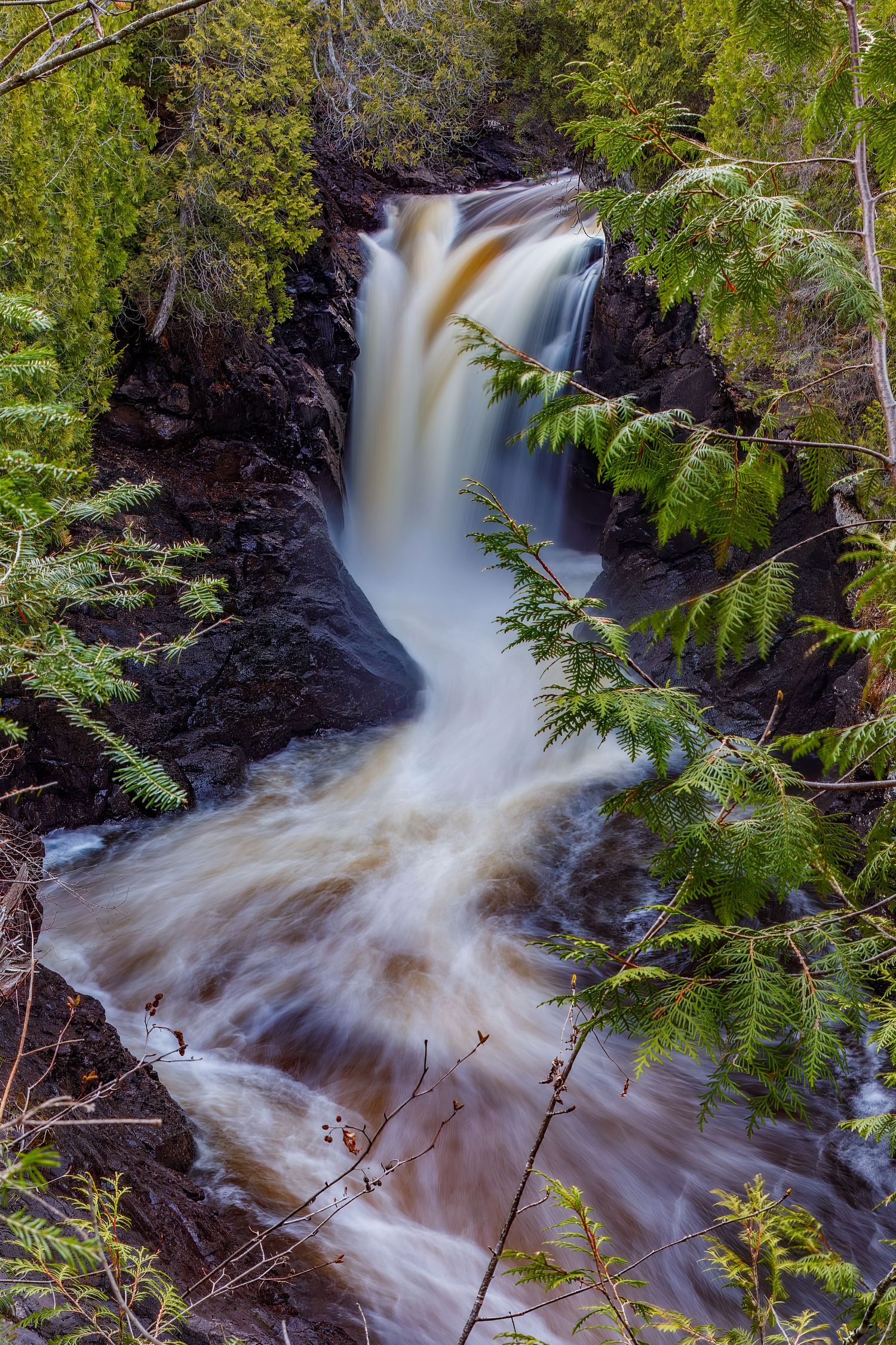 Long exposure waterfall landscape photography showing cascading water over rocks in Cascade Park, North Shore MN, calming nature wall art.