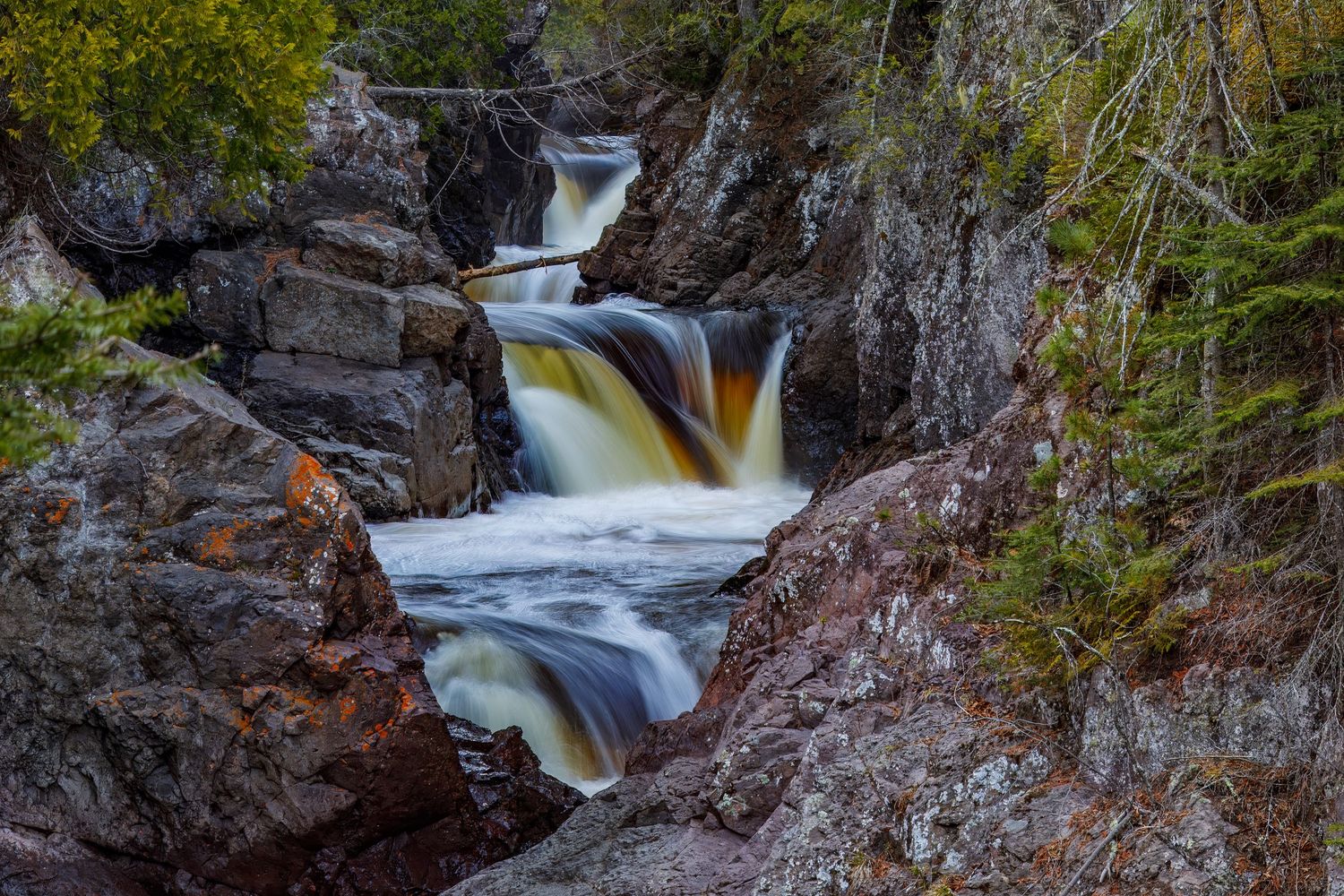 Long exposure waterfall landscape photography showing cascading water over rocks in Cascade Park, North Shore MN, calming nature wall art.