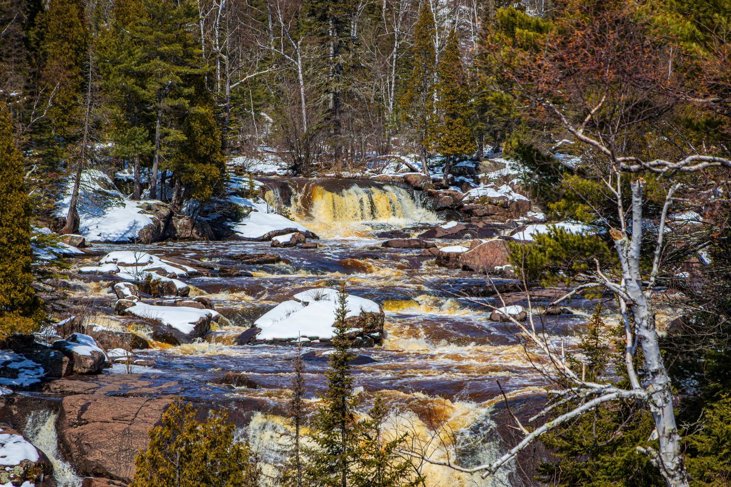Long exposure waterfall landscape photography showing cascading water over mossy rocks in forests of Northern MN, calming nature wall art.