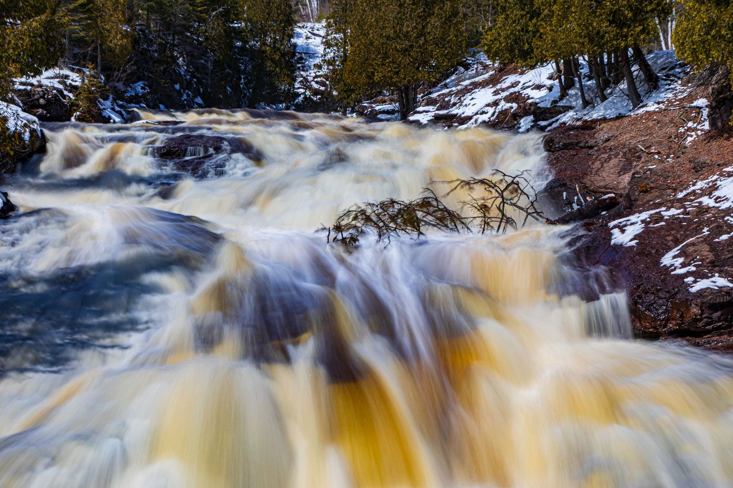 Long exposure waterfall landscape photography showing cascading water over mossy rocks in forests of Northern MN, calming nature wall art.