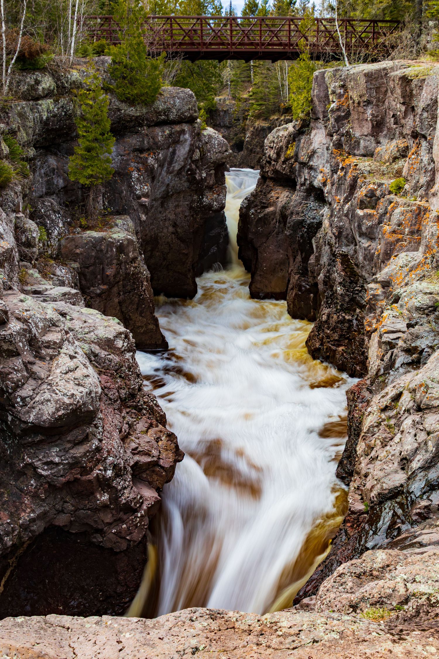 Long exposure waterfall landscape photography showing cascading water over mossy on the Temperance river in forest, calming nature wall art.
