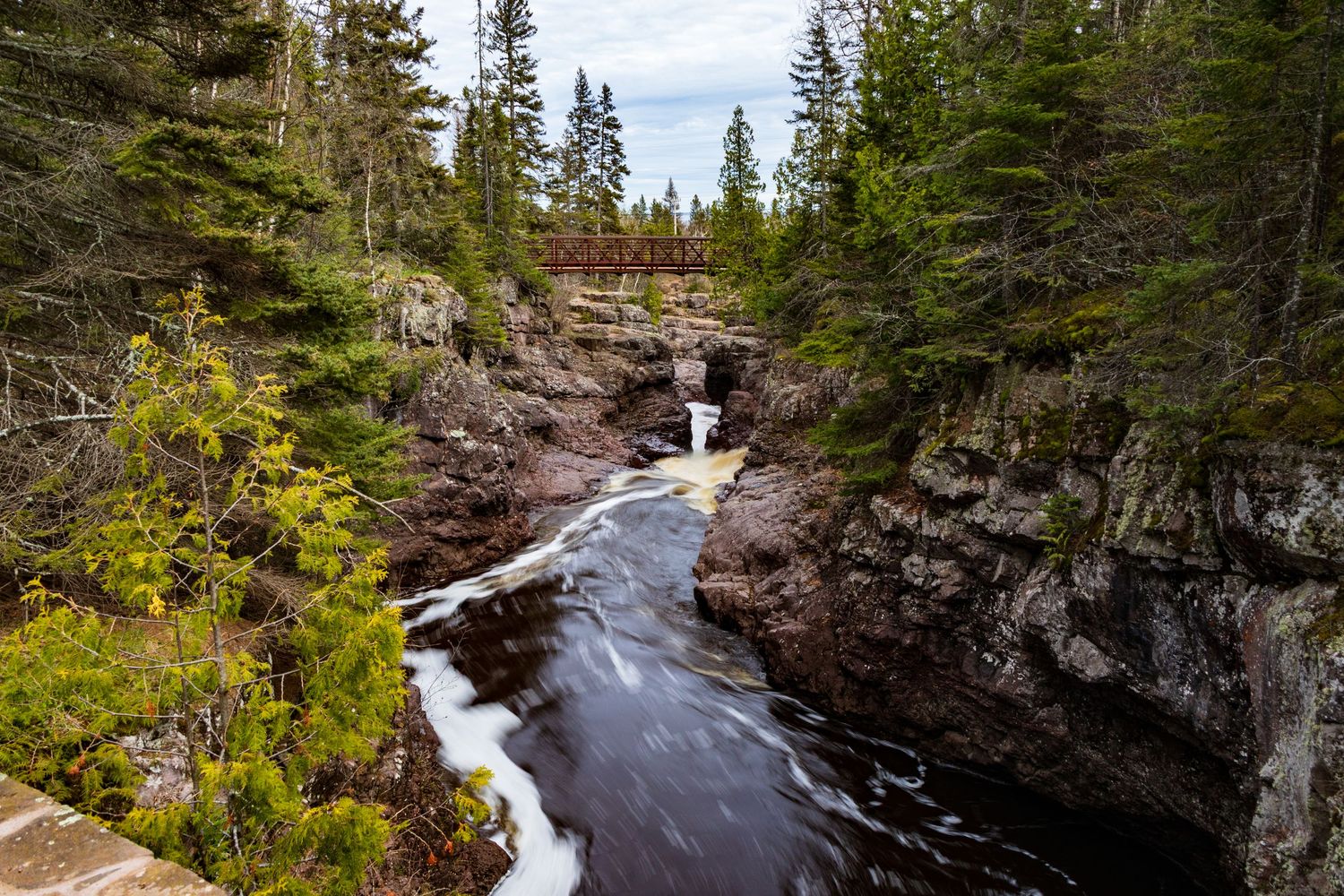 Long exposure waterfall landscape photography showing cascading water over mossy rocks on the Temperance River, calming nature wall art.
