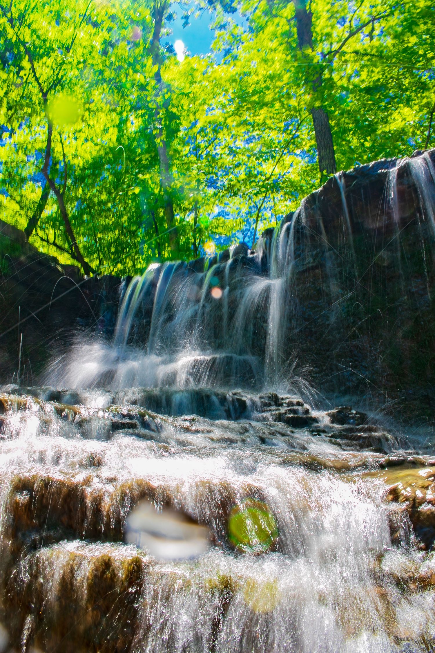 Long exposure waterfall landscape photography showing cascading water over mossy rocks in Minnesota, calming nature wall art.