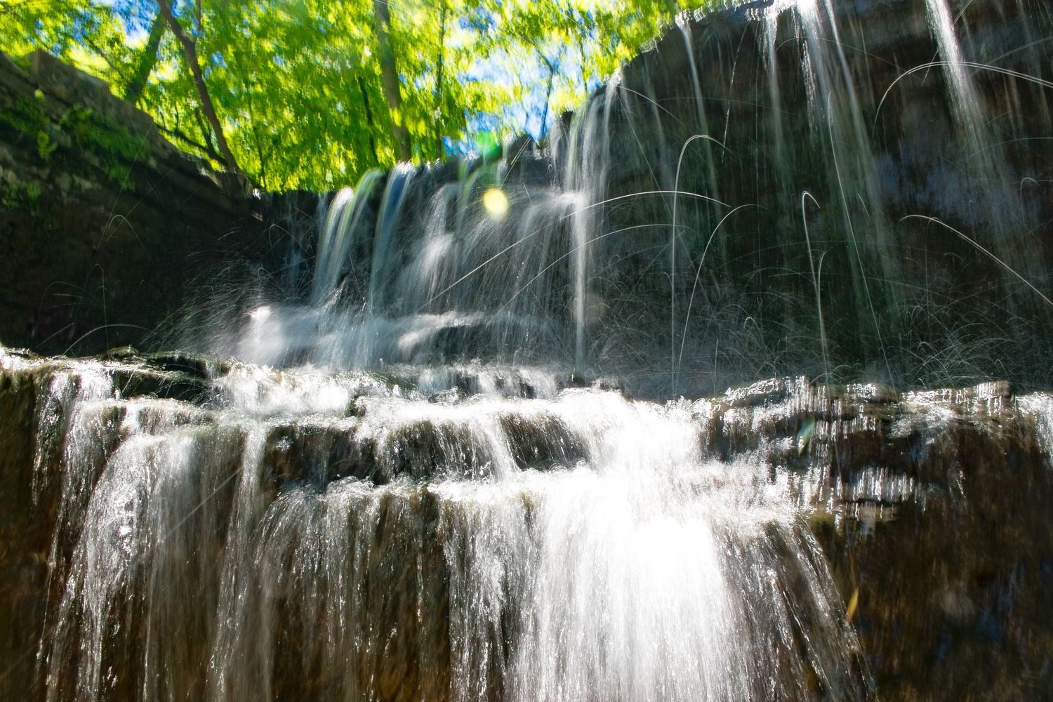 Long exposure waterfall landscape photography showing cascading water over mossy rocks in Minnesota, calming nature wall art.