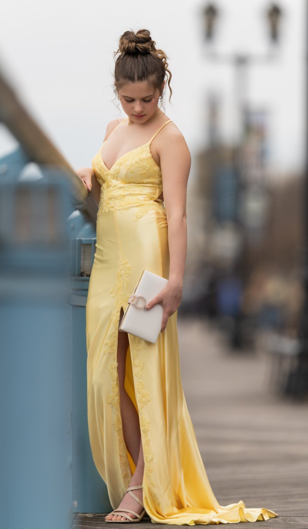 Close-up of Ava’s yellow prom dress and cream clutch during a Wilmington Riverfront prom session.