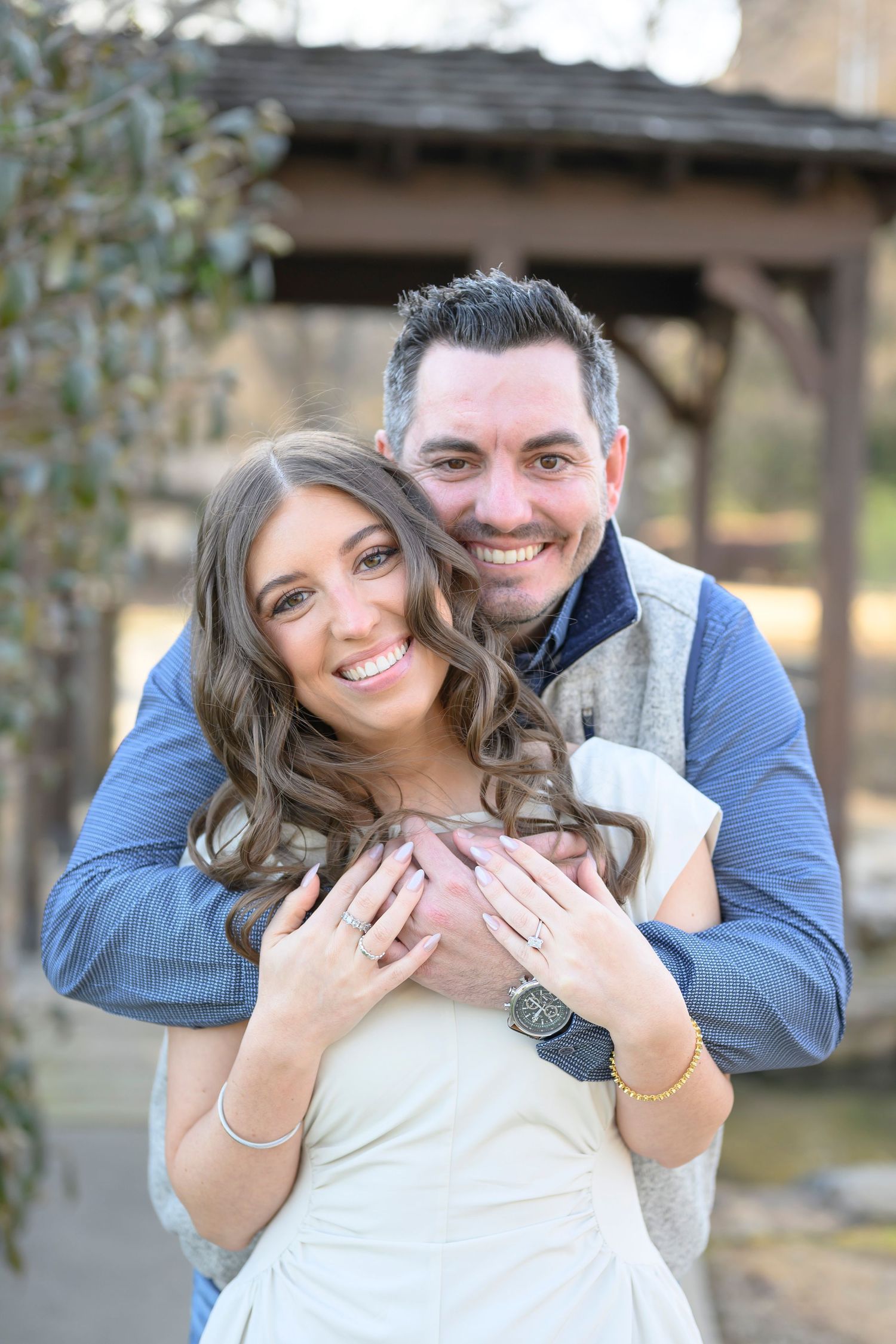A couple in love shows off their engagement ring in a series of romantic outdoor photos.