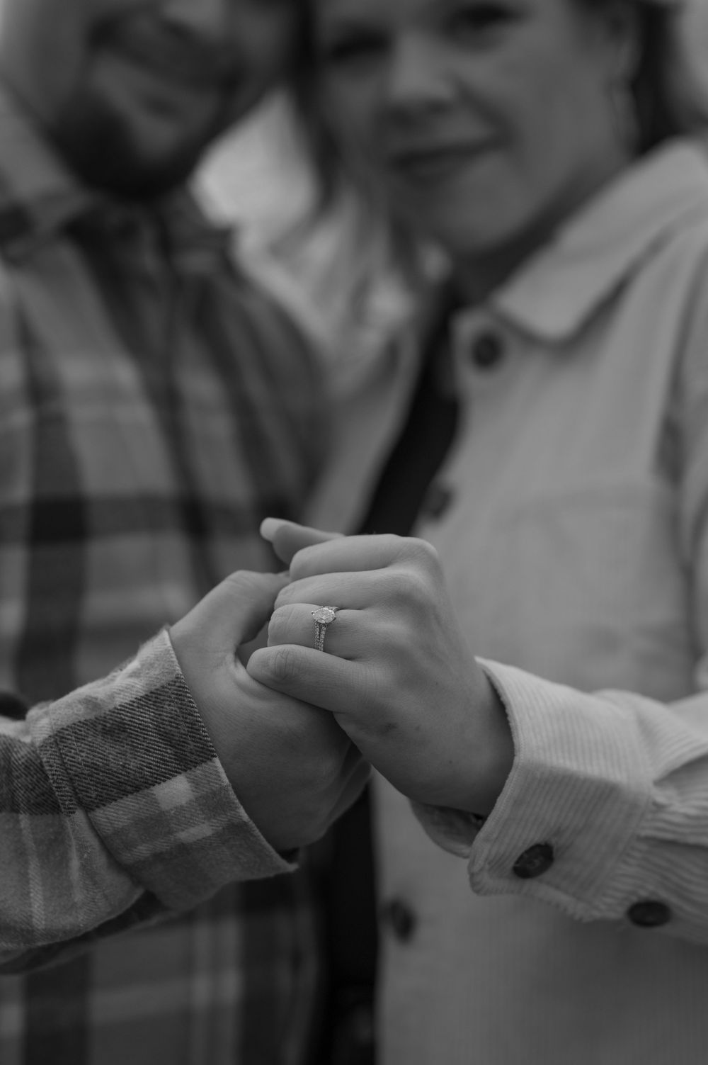 Close-up sequence of hands exchanging a ring in black and white.