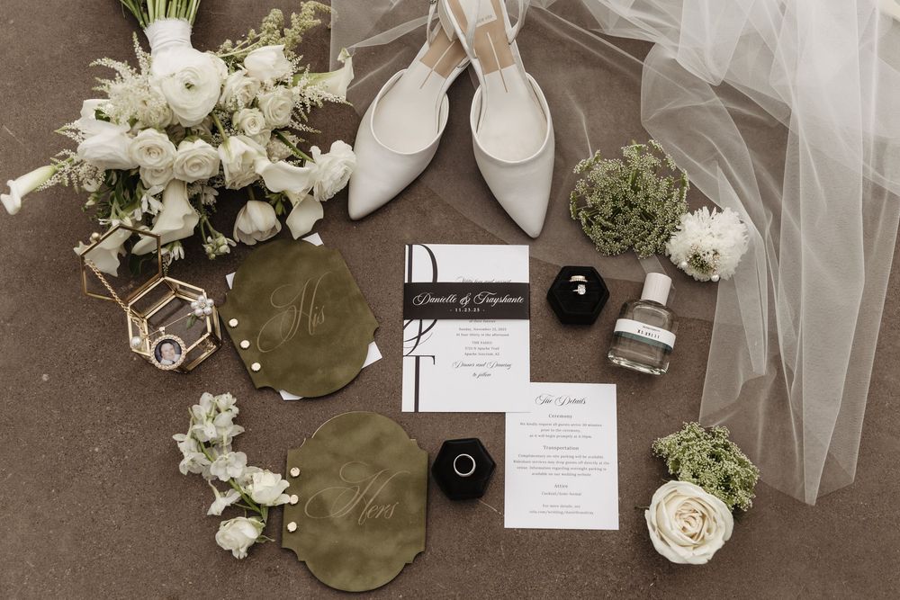 Wedding decorations featuring white floral arrangements, tulle fabric, and elegant place cards on a neutral surface.