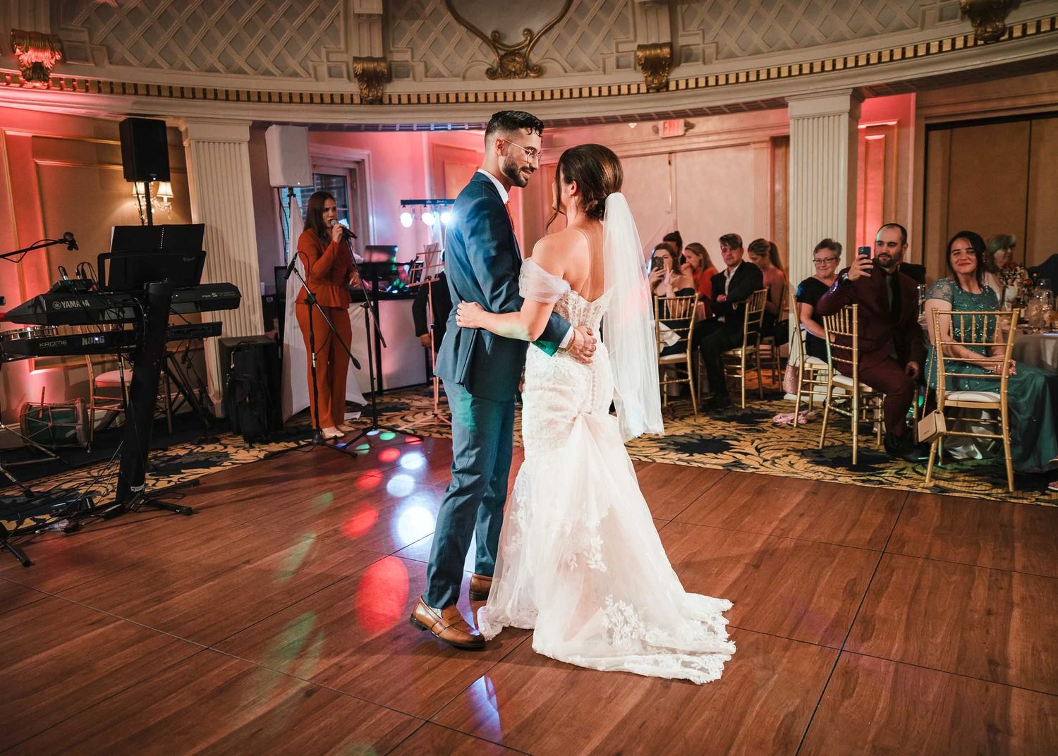 Bride and groom sharing their first dance during their Lenox Hotel Boston wedding reception in the Dome Room while guests watch