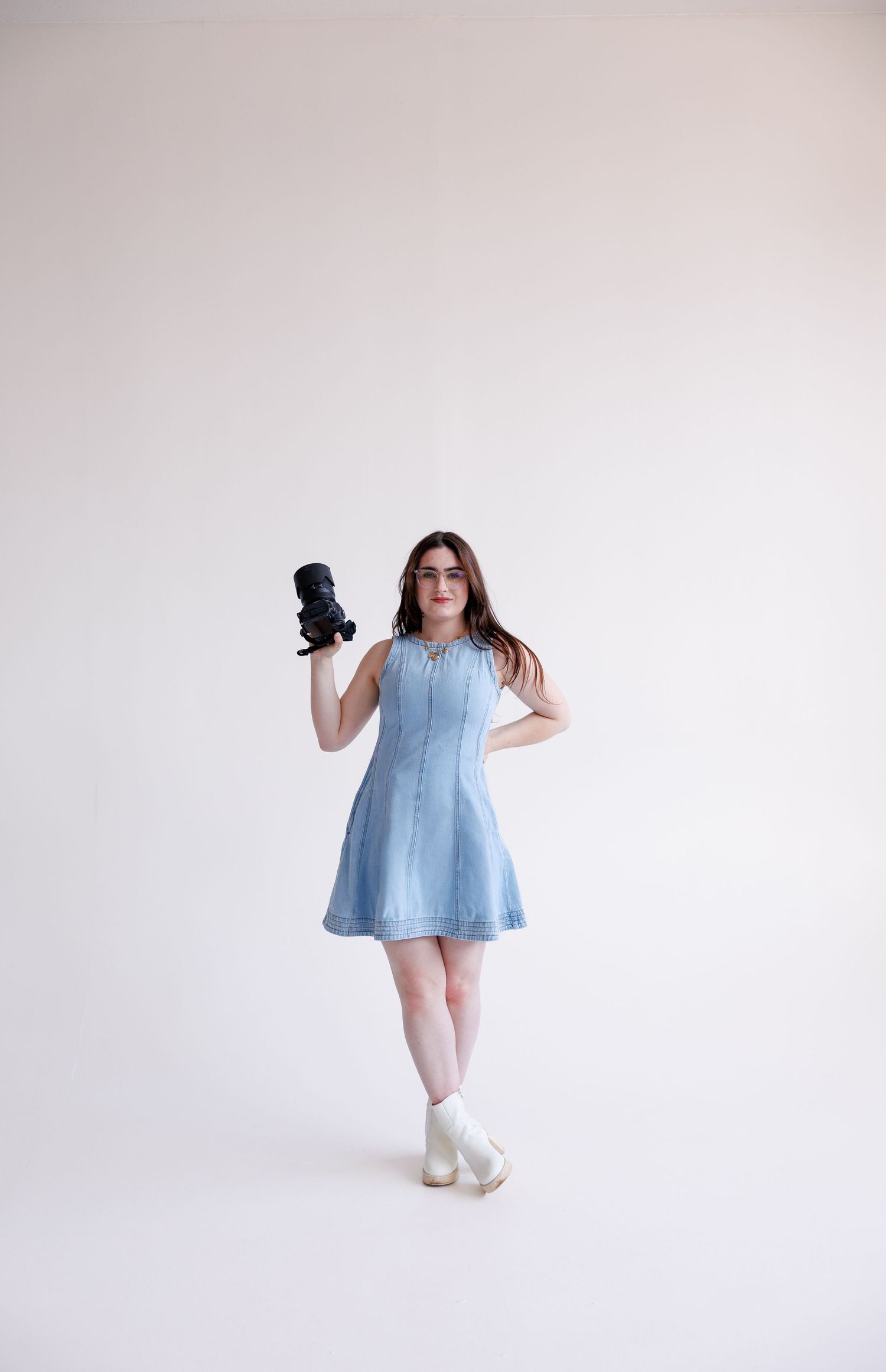 A person in a light blue dress and white socks poses against a white background in a sequence of dance-like movements.