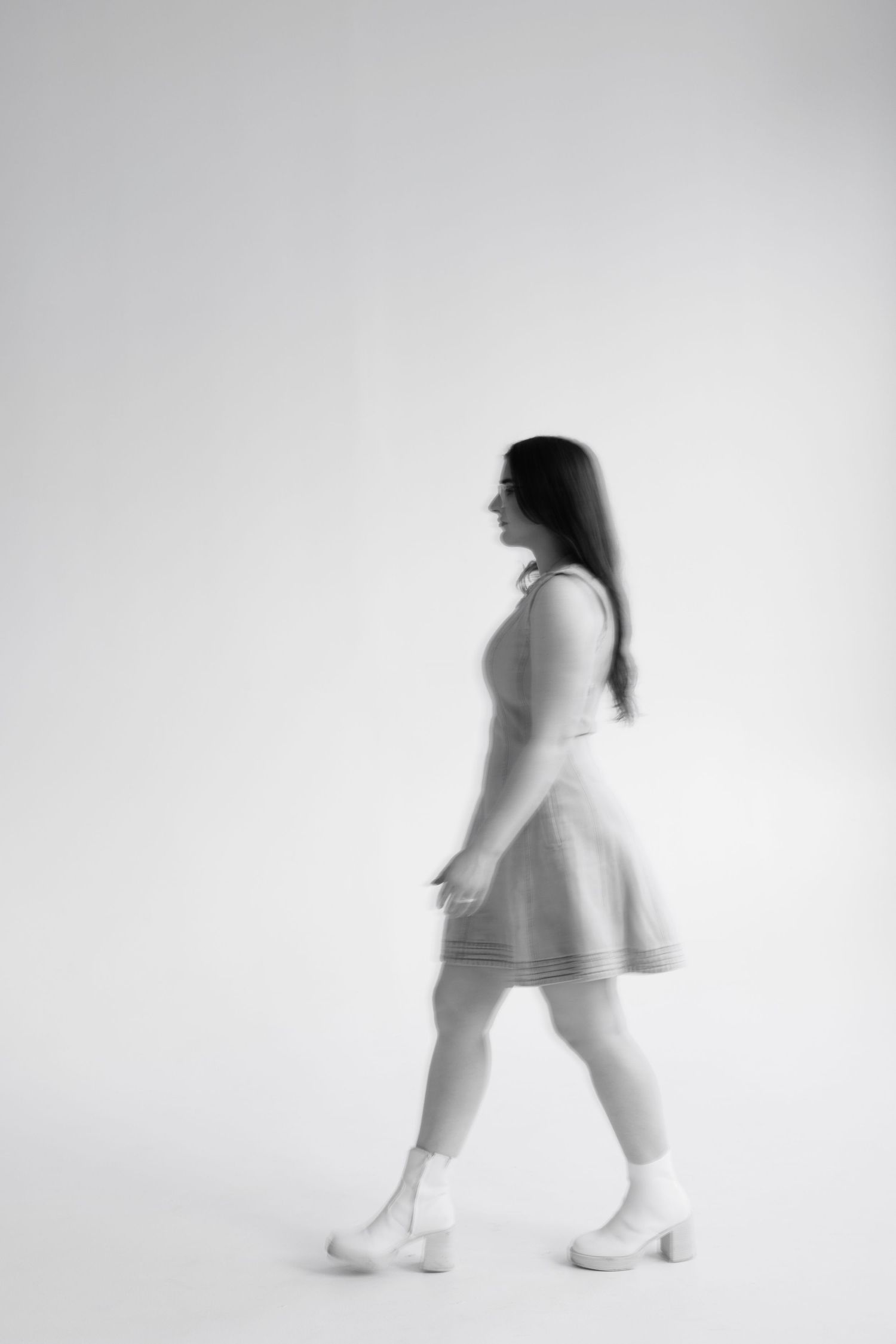 Artistic black and white sequence showing a figure in motion walking from right to left against a white background.