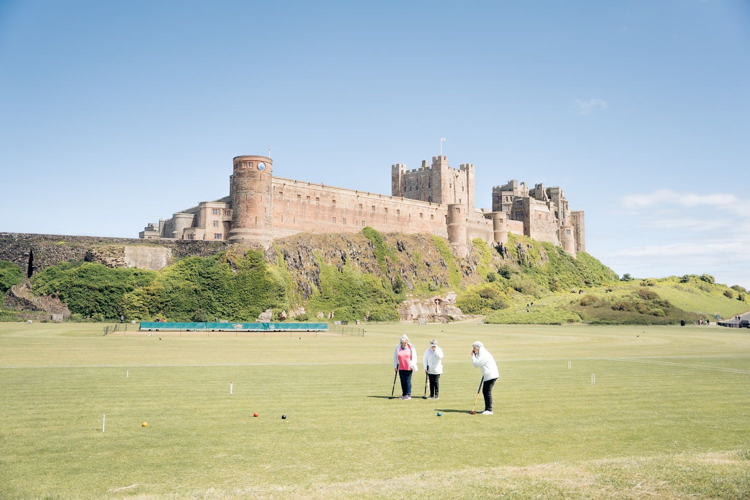 Groupe de femmes jouant au croquet devant le château de Bamburgh en Angleterre