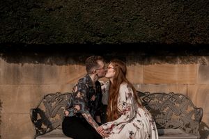A couple embraces in a series of romantic poses against a rustic stone backdrop with natural lighting.