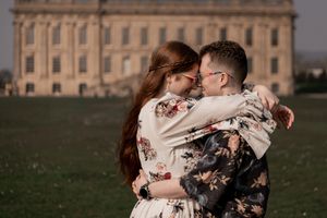 A tender embrace captured in front of a grand historic building.