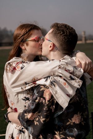 A romantic moment shared between a couple wearing coordinating floral outfits in an outdoor setting.