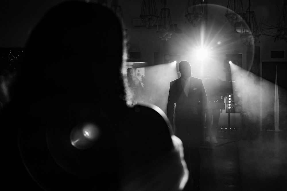 Dramatic black and white film noir style sequence showing silhouetted figures in dark alleyways and doorways.