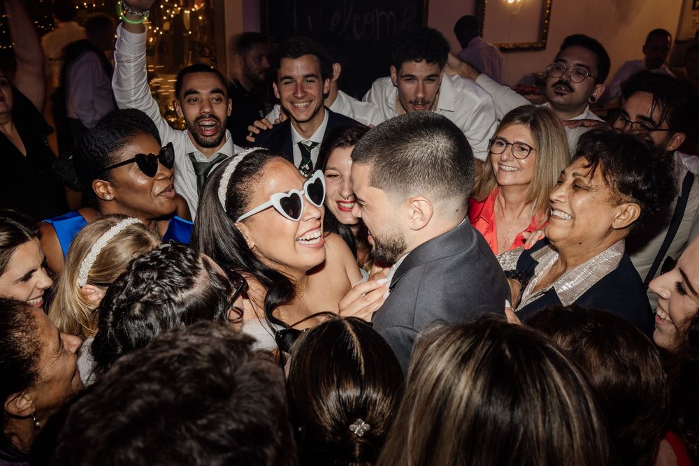 A crowded nightclub dance floor filled with people enjoying music and dancing under dim lighting.